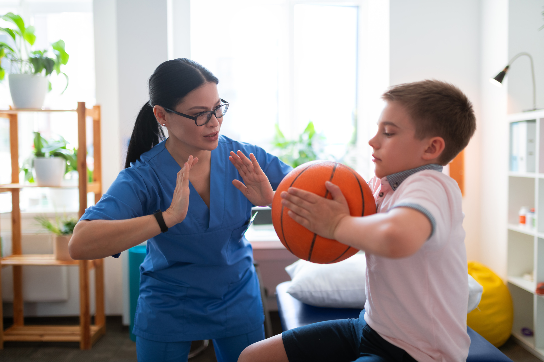 Patient throwing basketball with a clinician